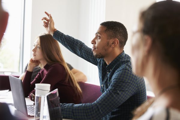 Student raising hand during private tuition course UK